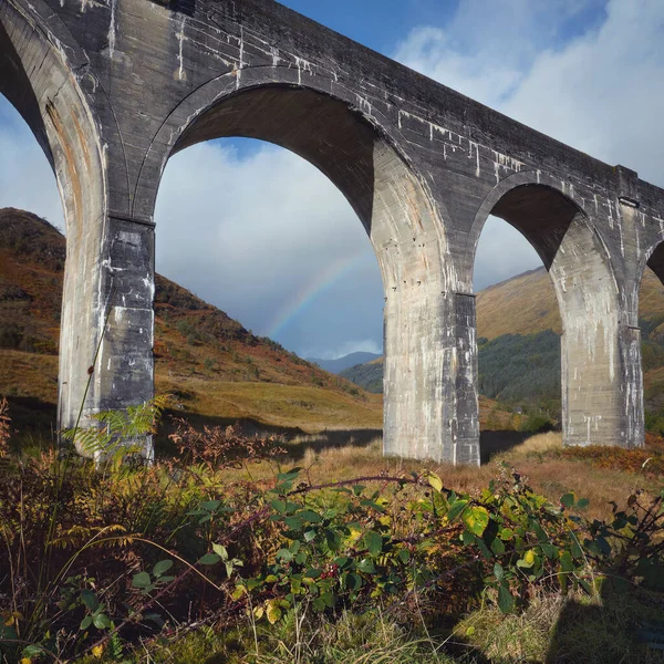 Vista inferior da ponte arqueada velha ou viaduto com um arco-íris — Fotografia de Stock