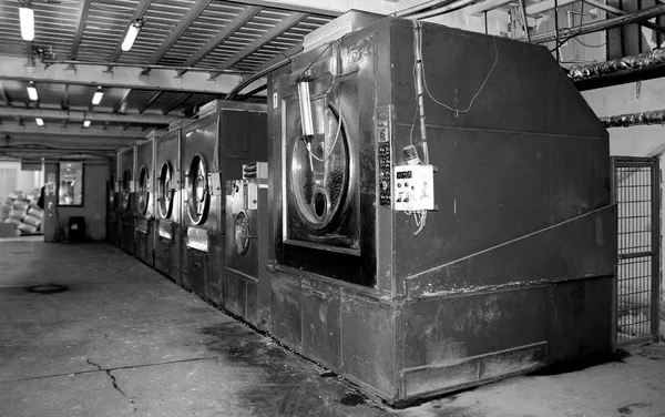 Black photo of old laundry shop with old washing machine and slippery jeans