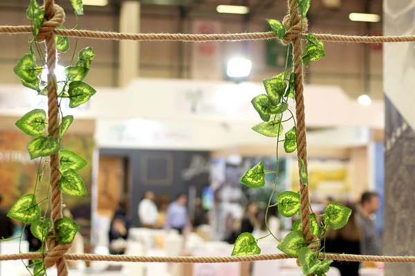 Frame and frame of brown rope and green leaves tied together at an exhibition crowded