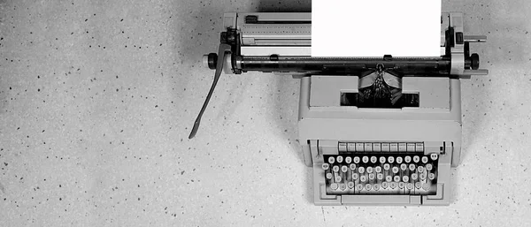 Una foto de un viejo dispositivo de mecanografía con papel blanco Imágenes De Stock Sin Royalties Gratis