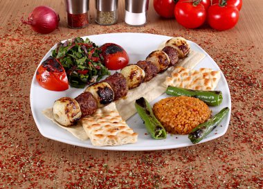 Izgara et, soğan, domates ve grits beyaz bir tabak üzerinde bir