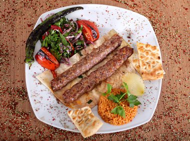 Türk spi ile dolu ahşap bir masada kızarmış hindi kebabı.