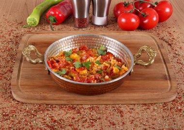 Kahvaltı için bakır tabakta yumurta ve domates omleti.