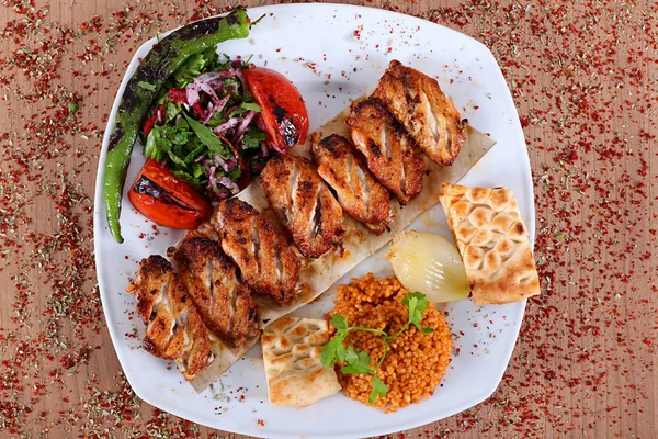 Alitas de pollo asadas servidas en un plato blanco con cebolla de pimientos — Foto de Stock