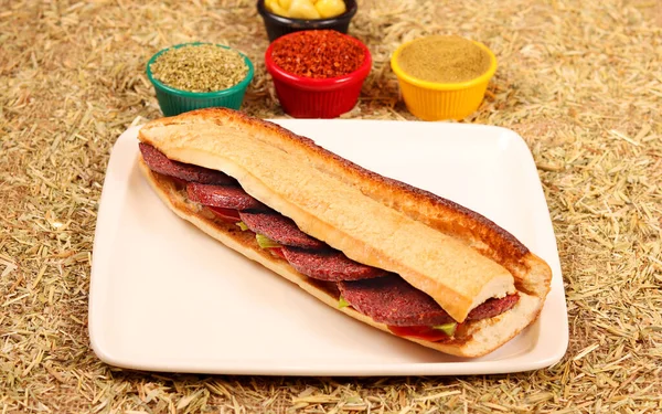 Sosisli, sebzeli, taze ekmekli, biberli ve baharatlı bir sandviç.