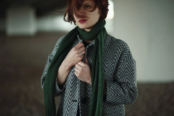 Kadın sütunun önünde duruyor.