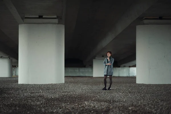 Kadın sütunun önünde duruyor.