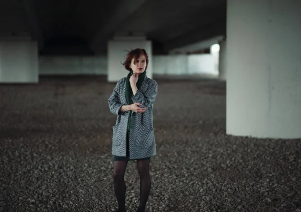 Kadın sütunun önünde duruyor.