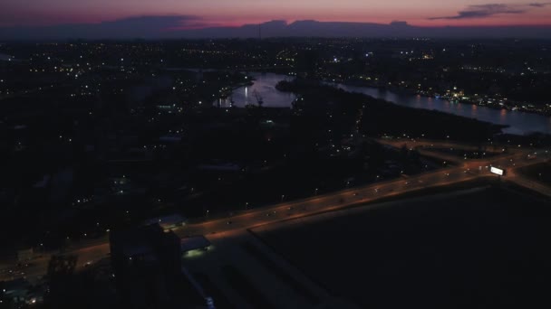 Rivier, brug en weg in nachtverlichting, uitzicht vanaf een hoogte van verre — Stockvideo