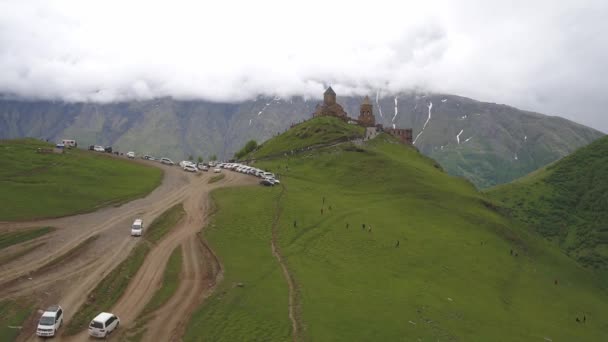 Грузія-10 червня 2018: Троїцька церква в Гергеті, Православна Церква біля підніжжя Казбек, вид з повітря — стокове відео