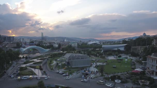 Tiflis, Georgien - Juni 2018: Rikiepark, Kura-Fluss und Friedensbrücke bei Sonnenuntergang, Luftaufnahme — Stockvideo