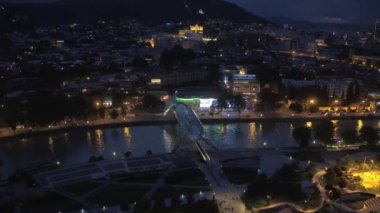Tiflis, Gürcistan - Haziran 2018: Kura Nehri ve Barış Köprüsü gece aydınlığında, yüksek bir yerden