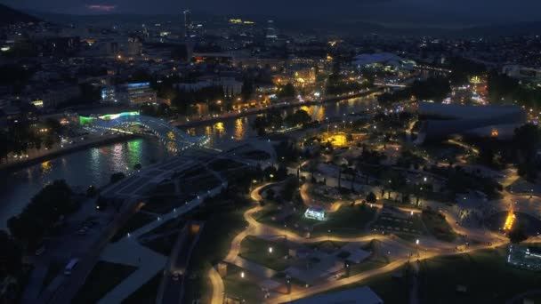 Tbilisi, Gruzja - czerwiec 2018: nocne miasto z góry - Rike park, rzeka Kura, Peace Bridge w oświetleniu nocnym — Wideo stockowe