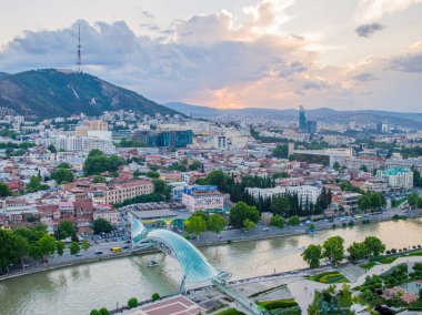 Tiflis, Gürcistan - Haziran 2018: Kura Nehri ve Barış Köprüsü gün batımında, hava manzaralı
