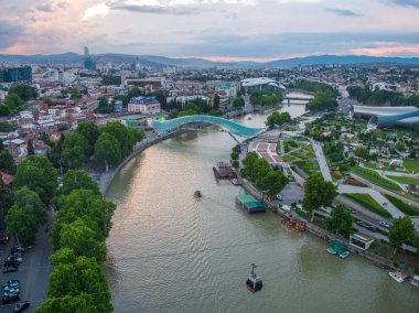 Tiflis, Gürcistan - Haziran 2018: Rike Park, Kura Nehri, Barış Köprüsü ve günbatımında füniküler, hava manzarası