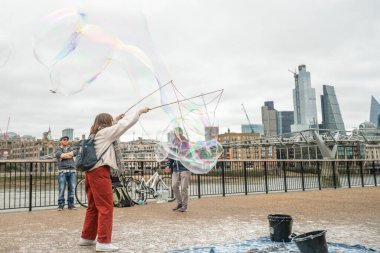 Londra, Uk - Ekim 2019: Dev sabun köpükleri gösterisi - sokak sanatçıları turistleri eğlendiriyor