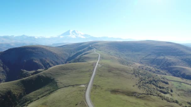 Hermoso paisaje de montaña desde una altura, picos nevados, un camino, región de Elbrus, Rusia — Vídeos de Stock