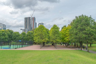 Londra - Ekim 2019: Vauxhall Eğlence Bahçeleri - spor sahası, sarı-yeşil ağaçlar, insanlar sokak boyunca yürüyor