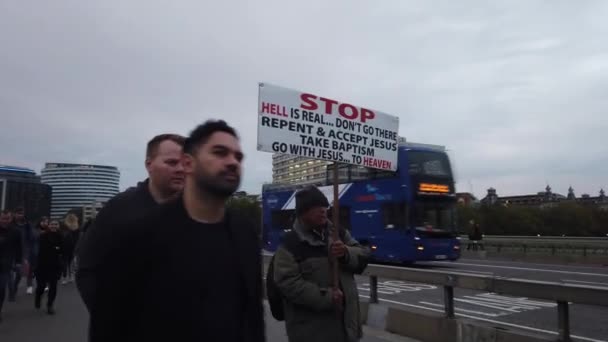 London - 2019. október: Westminster Bridge, egy ember zászlóval, az emberek sétálnak, buszokkal és autókkal — Stock videók