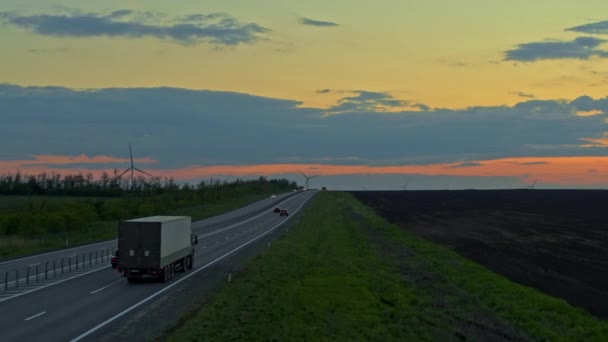 Highway från ovan, vacker solnedgång himmel, väderkvarnar i fjärran — Stockvideo
