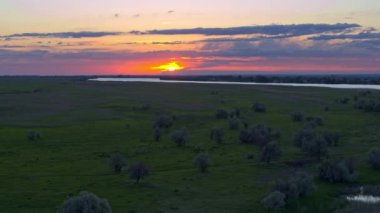 Yukarıdan güzel manzara, çayır ve ağaçlar, nehir ve günbatımı gökyüzü