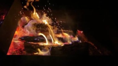 Yakacak odun gece barbeküde yanıyor, alev, yakın plan.