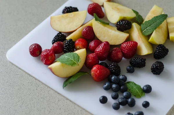 Maçãs Frescas Fatiadas Morangos Mirtilos Amoras Folhas Hortelã Redor Frutas — Fotografia de Stock