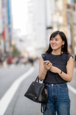 Cep telefonu tutan şehir güzel bir Japon Bayan.