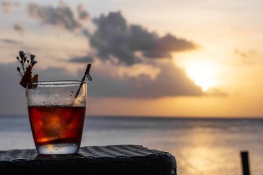 Deniz üzerinde gün batımı önünde izole buzlu bir yaz kokteyli