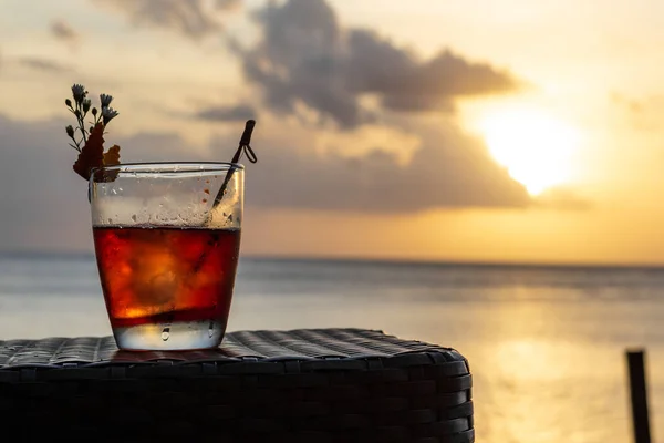 Un cocktail estivo ghiacciato isolato di fronte ad un tramonto sul mare — Foto Stock