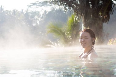 Sonsuzluk havuzunda dinlenen genç bir kadın