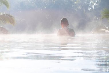 Sonsuzluk havuzunda dinlenen genç bir kadın