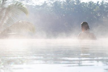 Sonsuzluk havuzunda dinlenen genç bir kadın