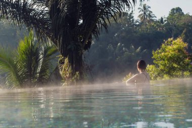 Sonsuzluk havuzunda dinlenen genç bir kadın