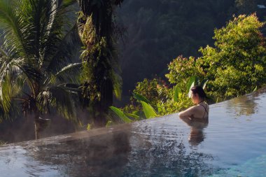 Sonsuzluk havuzunda dinlenen genç bir kadın