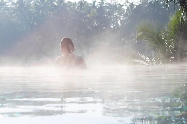 Een jonge vrouw ontspannen in een infinity pool — Stockfoto
