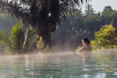 Sonsuzluk havuzunda dinlenen genç bir kadın