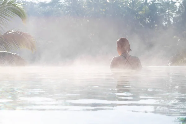 Een jonge vrouw ontspannen in een infinity pool — Stockfoto