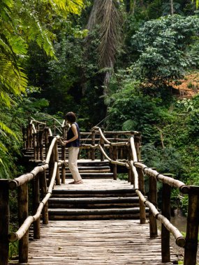 Bambu köprüsünde genç ve şık bir kadın