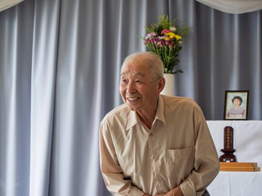 Yaşlı bir Asyalı aile etkinliğinde konuşma yapıyor.