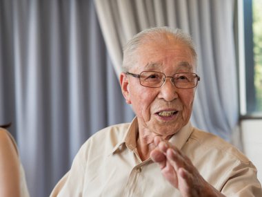 Bir aile etkinliğinde canlı canlı konuşan yaşlı bir adam.