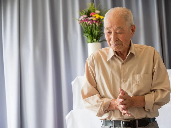 En eldre asiatisk mann holder tale på en familiesammenkomst stockfoto