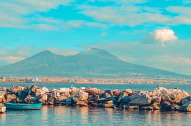 Kayalar ve mavi tekne ile Vezüv Yanardağı ve Napoli Körfezi görünümü. Napoli, İtalya