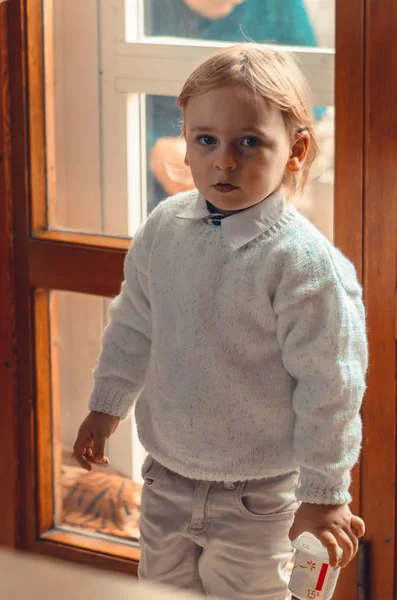 Красивий Світлий Маленький Хлопчик Стоїть Біля Вікна Йогуртом Руці — стокове фото
