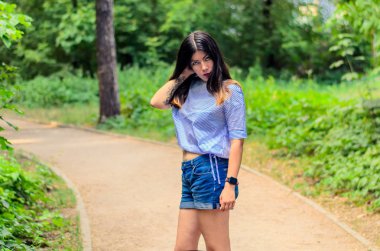 Güzel, genç, mutlu esmer bir kadının portresi. Taze ve temiz tenli. Açık yaz caddesi.