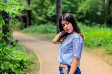 Güzel, şehvetli, esmer, dövmeli ve uzun siyah saçlı bir kadının portresi..