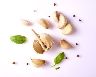 Taze sarımsak, fesleğen yaprakları ve beyaz arka plan üzerinde izole biber ile kompozisyon