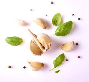 Taze sarımsak, fesleğen yaprakları ve beyaz arka plan üzerinde izole biber ile kompozisyon