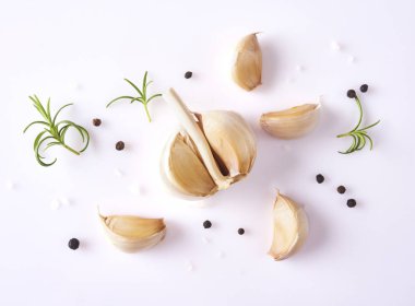 Gıda kavramı. Taze sarımsak, biberiye yaprağı ve beyaz arka plan üzerinde izole biber ile kompozisyon