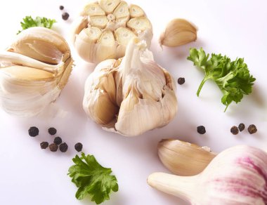 Gıda kavramı. Taze sarımsak, kişniş yaprakları ve beyaz arka plan üzerinde izole biber ile kompozisyon